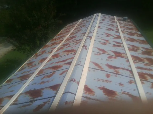Rusted metal roof panels with new wood purlins before replacement — Storm Damage Roof Repair in Staley by Roofing Brothers
