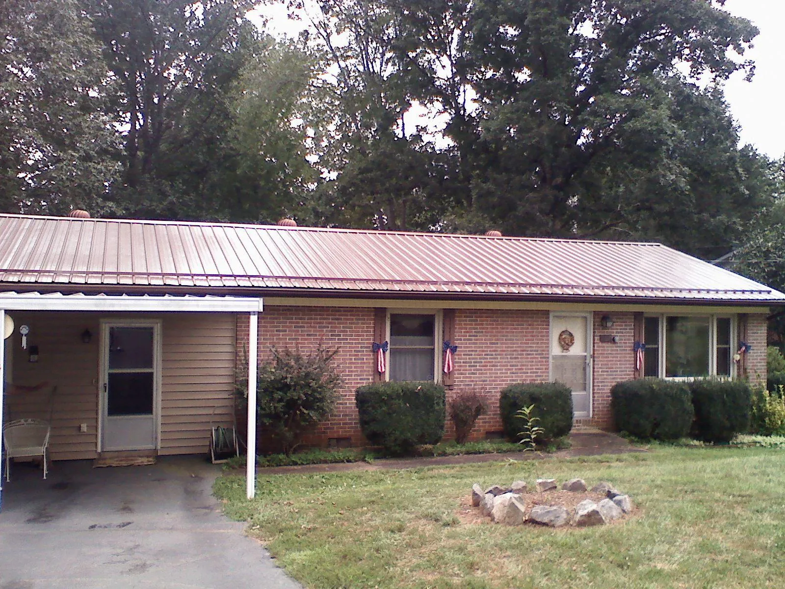 Bronze metal roof and carport on a brick ranch home — Roof Repair work by our crew in Staley